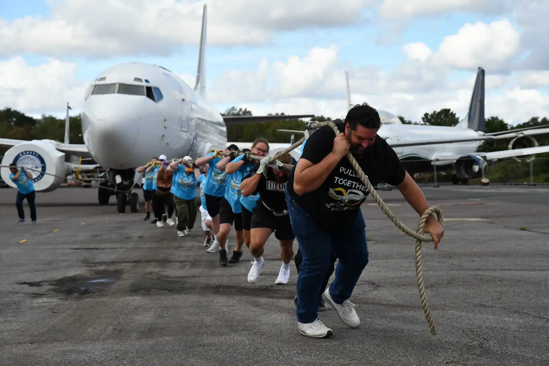 Part of the Flight Risk team on the tarmac, pulling a Boeing 737 using a rope over the shoulders. 