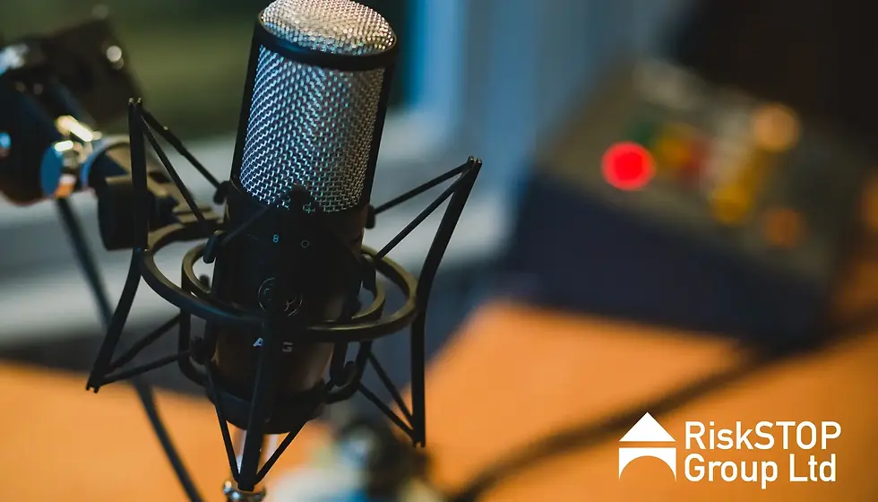 Close-up of a microphone in a radio studio setting with blurred background. 